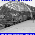 A black and white cover of the "Somerset & Dorset" photo book from the R C Riley archive, showing a locomotive and its wagons standing on a platform, with one person pictured nearby and the train station infrastructure in the background.